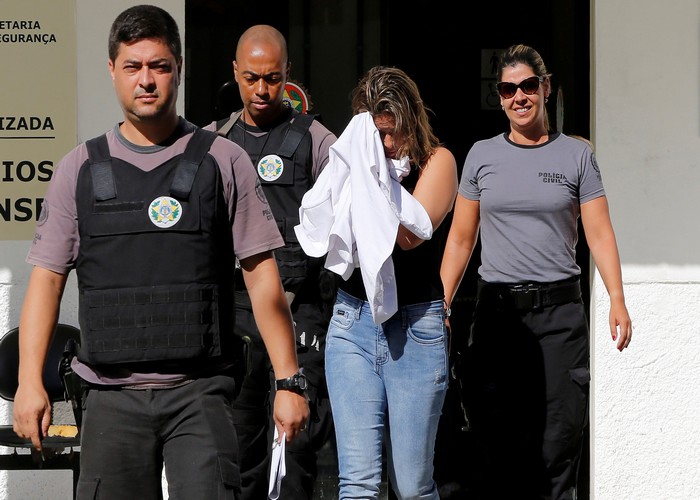 Francoise Souza Oliveira, 40, wife of Greek Ambassador for Brazil Kyriakos Amiridis, is escorted by police officers as she is transferred from the police station to a jail in Belford Roxo, Brazil December 31, 2016. REUTERS/Marcos de Paula   FOR EDITORIAL USE ONLY. NO RESALES. NO ARCHIVES