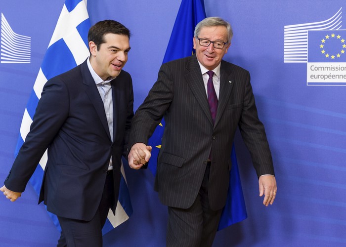 European Commission President Jean-Claude Juncker, right, walks hand in hand with Greece's Prime Minister Alexis Tsipras upon his arrival at the European Commission headquarters in Brussels Wednesday, Feb. 4, 2015. Tsiparis is on a one day trip to Brussels to meet with EU leaders.(AP Photo/Geert Vanden Wijngaert)
