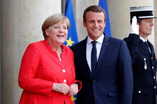 French President Emmanuel Macron (R) greets German Chancellor Angela Merkel as she arrives for talks on EU integration, defense and migration at the Elysee Palace in Paris, France, August 28, 2017.  REUTERS/Charles Platiau