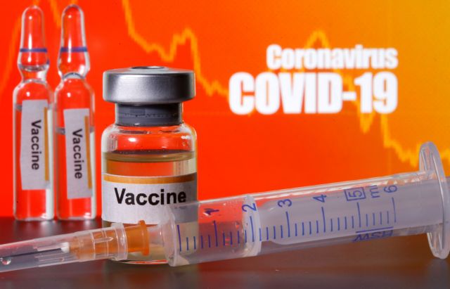 FILE PHOTO: Small bottles labelled with "Vaccine" stickers seen near a medical syringe in front of displayed "Coronavirus COVID-19" words in this illustration taken April 10, 2020. REUTERS/Dado Ruvic/Illustration/File Photo