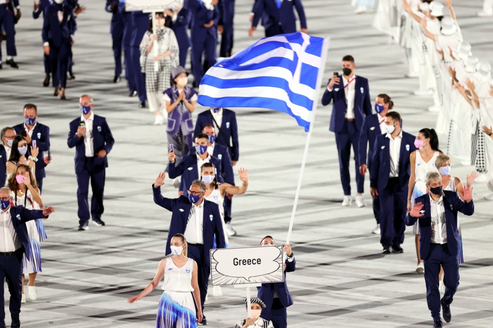 epa09359566 
Flag Bearers of Greece Anna Korakaki (L) and Eleftherios Petrounias enter the stadium during the Opening Ceremony of the Tokyo 2020 Olympic Games at the Olympic Stadium in Tokyo, Japan, 23 July 2021.  EPA/RITCHIE B. TONGO