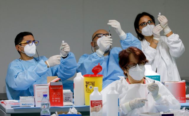 FILE PHOTO: Health workers prepare doses of the Pfizer-BioNTech COVID-19 vaccine at an inoculation centre in Naples, Italy, January 8, 2021. REUTERS/Ciro De Luca/File Photo