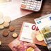 Euro banknotes and coins with bills to pay. Finances and budget concept