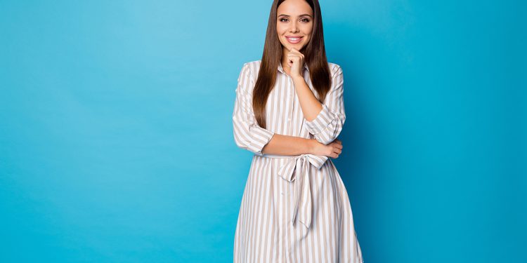 Photo of pretty attractive lady good mood beaming smile hold hand on chin intelligent, person wear striped casual summer short dress isolated blue color background