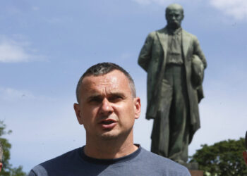 Ukrainian filmmaker and former Russian prisoner Oleg Sentsov, center, talks to reporters during an outdoor press conference in front of a monument to national poet Taras Shevchenko in Kyiv, Ukraine, Friday, June 19, 2020. Sentsov and other former Russian prisoners demanded the Ukrainian authorities to stop political repressions. (AP Photo/Efrem Lukatsky)