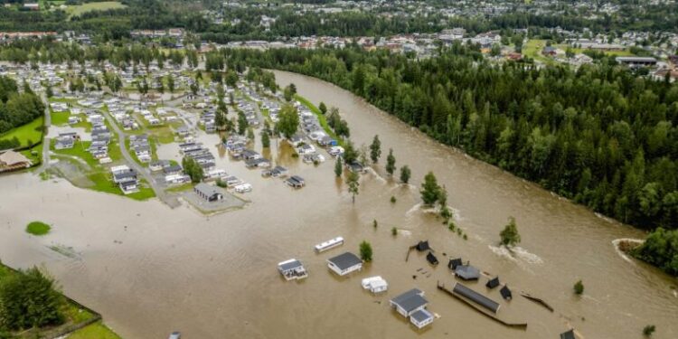 This aerial view taken on August 9, 2023 shows the camping site in Dokka flooded after the Dokka River overflowed its banks. Heavy rains caused flooding and landslides in Sweden and Norway on August 8 while strong winds caused a Danish wildfire to spread out of control, authorities said, with more heavy rain forecast. A storm dubbed "Hans" swept in over the Nordic countries over the weekend, leaving a path of destruction. Norway police reported several landslides in the southeast, with media reporting that over 100 people had been evacuated as a result. (Photo by Stian Lysberg Solum / NTB / AFP) / Norway OUT