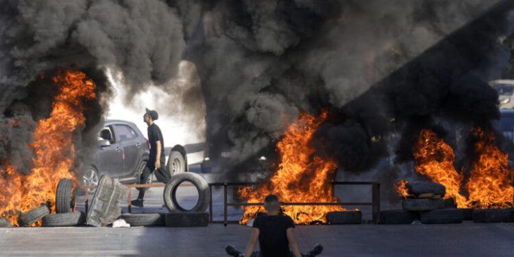 Tires set fire by Palestinians burn at the site where two Palestinians were shot and killed by the Israeli army in the Jalazone refugee camp near the city of Ramallah, West Bank, Monday, Oct. 3, 2022. Palestinian officials say the Israeli military has killed two Palestinians in the occupied West Bank. The Israeli military says it was on an arrest raid early Monday and alleges the two suspects tried to ram their car into soldiers, a claim that could not be independently verified. (AP Photo/Majdi Mohammed)