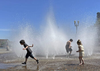 Children play in a fountain to cool off in downtown Portland, Ore., Friday, May 12, 2023. An early May heat wave this weekend could surpass daily records in parts of the Pacific Northwest and worsen wildfires already burning in western Canada, a historically temperate region that has grappled with scorching summer temperatures and unprecedented wildfires fueled by climate change in recent years. (AP Photo/Claire Rush)