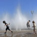 Children play in a fountain to cool off in downtown Portland, Ore., Friday, May 12, 2023. An early May heat wave this weekend could surpass daily records in parts of the Pacific Northwest and worsen wildfires already burning in western Canada, a historically temperate region that has grappled with scorching summer temperatures and unprecedented wildfires fueled by climate change in recent years. (AP Photo/Claire Rush)