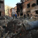 Local residents inspect damages outside an apartment building after the overnight Russian drones attack in Kharkiv, December 31, 2023, amid the Russian invasion of Ukraine. Kyiv said on December 31, 2023, it destroyed 21 of 49 Iranian-made "Shahed" drones fired by Russia overnight, adding that six guided missiles had also targeted the northeastern city of Kharkiv. (Photo by SERGEY BOBOK / AFP)