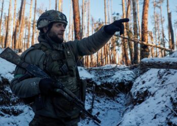 A Ukrainian serviceman of the First Presidential Brigade Bureviy (Hurricane) of the National Guard of Ukraine points a direction in a trench at a position in a frontline, amid Russia's attack on Ukraine, near the town of Kreminna, Eastern Ukraine, February 6, 2024. Radio Free Europe/Radio Liberty/Serhii Nuzhnenko via REUTERS