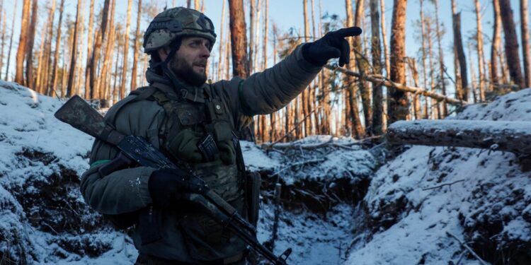 A Ukrainian serviceman of the First Presidential Brigade Bureviy (Hurricane) of the National Guard of Ukraine points a direction in a trench at a position in a frontline, amid Russia's attack on Ukraine, near the town of Kreminna, Eastern Ukraine, February 6, 2024. Radio Free Europe/Radio Liberty/Serhii Nuzhnenko via REUTERS
