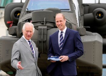 Britain's King Charles III officially hands over the role of Colonel-in-Chief of the Army Air Corps to Britain's Prince William, Prince of Wales in front of an Apache helicopter at the Army Aviation Centre in Middle Wallop, England, on May 13, 2024. (Photo by Kin Cheung / POOL / AFP)