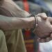 A handcuffed Spanish prisoner waits at a police base near the airport before his repatriation, in Callao, Peru, Thursday, March 16, 2017. A group of 50 Spanish citizens serving out long drug sentences are anxiously awaiting to be repatriated Thursday as part of an airlift brokered by the two governments. Peru is the world's second-largest cocaine producer, and much of the narcotics arriving in Europe passes through Spain, where traffickers prowl for recruits, offering a hefty sum to travel to Lima and bring back cocaine. There are currently more than 200 Spaniards in Peruvian prisons on drug charges, more inmates than from any other foreign country.  (AP Photo/Martin Mejia)