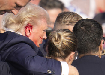 Republican presidential candidate former President Donald Trump is surround by U.S. Secret Service agents as he is helped off the stage at a campaign rally in Butler, Pa., Saturday, July 13, 2024. (AP Photo/Gene J. Puskar)