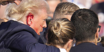 Republican presidential candidate former President Donald Trump is surround by U.S. Secret Service agents as he is helped off the stage at a campaign rally in Butler, Pa., Saturday, July 13, 2024. (AP Photo/Gene J. Puskar)