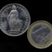 A Euro coin, right, and a Swiss Franc coin  have been placed on a table to be photographed in Gelsenkirchen, Germany, Thursday, Jan. 15, 2015. The European currency has  lost value after Switzerland's central bank said Thursday it has scrapped a policy that limited how much the euro could fall against the Swiss franc, an unexpected decision that caused gyrations in financial markets. (AP Photo/Martin Meissner)