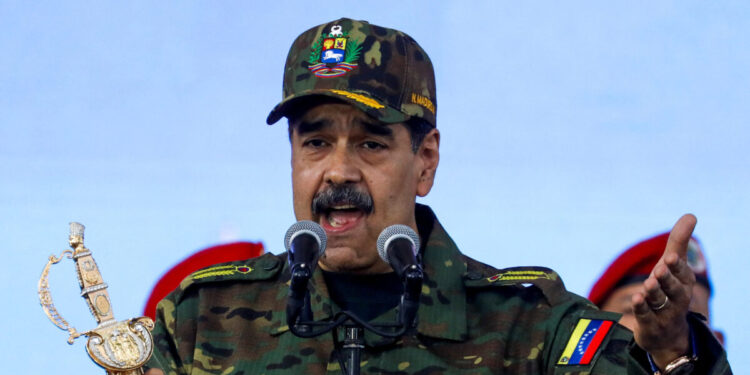 Venezuela's President Nicolas Maduro holds Simon Bolivar's sword as he addresses members of the armed forces, Bolivarian Militia, police, and civilians during a rally against a possible escalation of U.S. actions toward the country, at Fort Tiuna military base in Caracas, Venezuela, November 25, 2025. REUTERS/Leonardo Fernandez Viloria